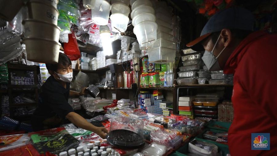 Pedagang melayani pembeli kantong plastik di Pasar Jaya Slipi, Jakarta, Rabu (9/3/2022). Lonjakan harga minyak mentah mendongkrak kenaikan harga bahan baku plastik. Baik untuk jenis Low Density Polyethylene (LDPE), Linear Low Density Polyethylene (LLDPE), High Density Polyethylene (HDPE), maupun Polypropylene (PP). (CNBC Indonesia/ Tri Susilo)