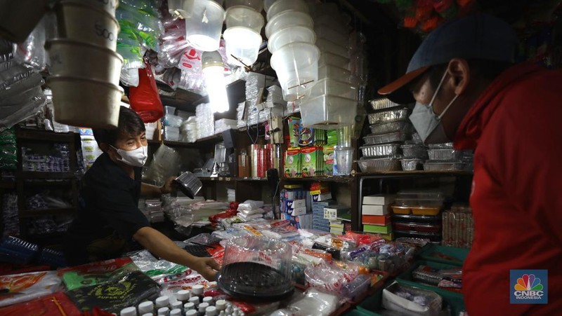 Pedagang melayani pembeli kantong plastik di Pasar Jaya Slipi, Jakarta, Rabu (9/3/2022). Lonjakan harga minyak mentah mendongkrak kenaikan harga bahan baku plastik. Baik untuk jenis Low Density Polyethylene (LDPE), Linear Low Density Polyethylene (LLDPE), High Density Polyethylene (HDPE), maupun Polypropylene (PP). (CNBC Indonesia/ Tri Susilo)