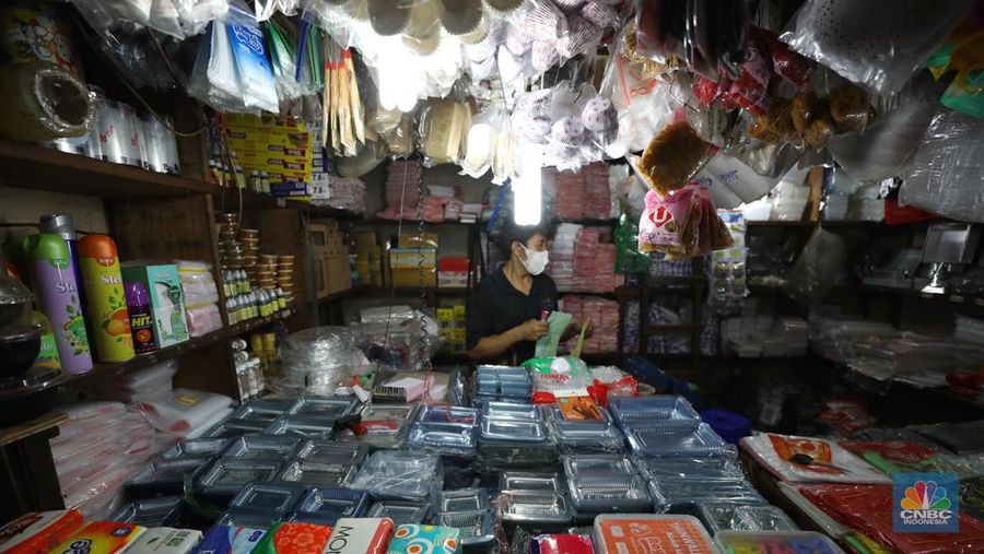 Pedagang melayani pembeli kantong plastik di Pasar Jaya Slipi, Jakarta, Rabu (9/3/2022). Lonjakan harga minyak mentah mendongkrak kenaikan harga bahan baku plastik. Baik untuk jenis Low Density Polyethylene (LDPE), Linear Low Density Polyethylene (LLDPE), High Density Polyethylene (HDPE), maupun Polypropylene (PP). (CNBC Indonesia/ Tri Susilo)