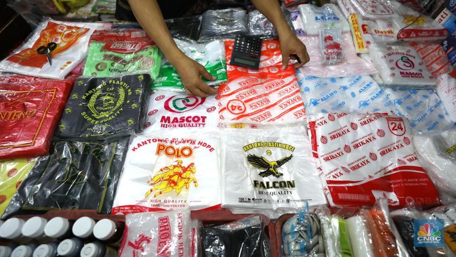Pedagang melayani pembeli kantong plastik di Pasar Jaya Slipi, Jakarta, Rabu (9/3/2022). Lonjakan harga minyak mentah mendongkrak kenaikan harga bahan baku plastik. Baik untuk jenis Low Density Polyethylene (LDPE), Linear Low Density Polyethylene (LLDPE), High Density Polyethylene (HDPE), maupun Polypropylene (PP). (CNBC Indonesia/ Tri Susilo)