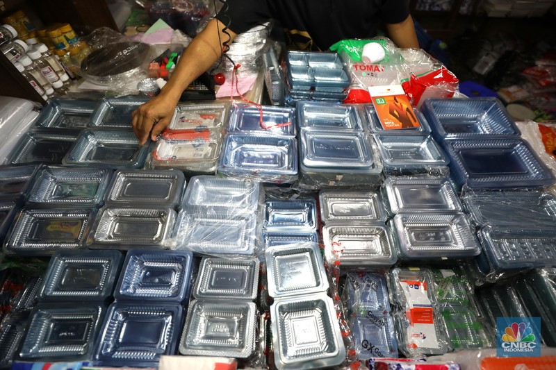 Pedagang melayani pembeli kantong plastik di Pasar Jaya Slipi, Jakarta, Rabu (9/3/2022). Lonjakan harga minyak mentah mendongkrak kenaikan harga bahan baku plastik. Baik untuk jenis Low Density Polyethylene (LDPE), Linear Low Density Polyethylene (LLDPE), High Density Polyethylene (HDPE), maupun Polypropylene (PP). (CNBC Indonesia/ Tri Susilo)
