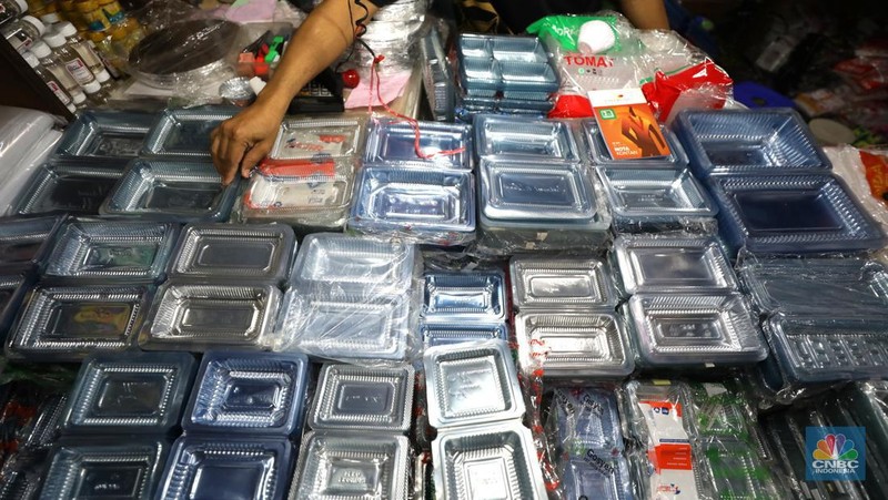 Pedagang melayani pembeli kantong plastik di Pasar Jaya Slipi, Jakarta, Rabu (9/3/2022). Lonjakan harga minyak mentah mendongkrak kenaikan harga bahan baku plastik. Baik untuk jenis Low Density Polyethylene (LDPE), Linear Low Density Polyethylene (LLDPE), High Density Polyethylene (HDPE), maupun Polypropylene (PP). (CNBC Indonesia/ Tri Susilo)