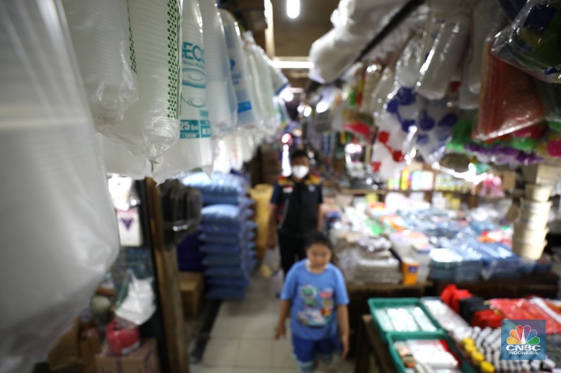 Pedagang melayani pembeli kantong plastik di Pasar Jaya Slipi, Jakarta, Rabu (9/3/2022). Lonjakan harga minyak mentah mendongkrak kenaikan harga bahan baku plastik. Baik untuk jenis Low Density Polyethylene (LDPE), Linear Low Density Polyethylene (LLDPE), High Density Polyethylene (HDPE), maupun Polypropylene (PP). (CNBC Indonesia/ Tri Susilo)