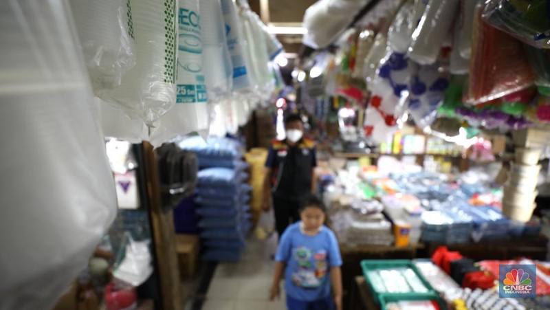 Pedagang melayani pembeli kantong plastik di Pasar Jaya Slipi, Jakarta, Rabu (9/3/2022). Lonjakan harga minyak mentah mendongkrak kenaikan harga bahan baku plastik. Baik untuk jenis Low Density Polyethylene (LDPE), Linear Low Density Polyethylene (LLDPE), High Density Polyethylene (HDPE), maupun Polypropylene (PP). (CNBC Indonesia/ Tri Susilo)