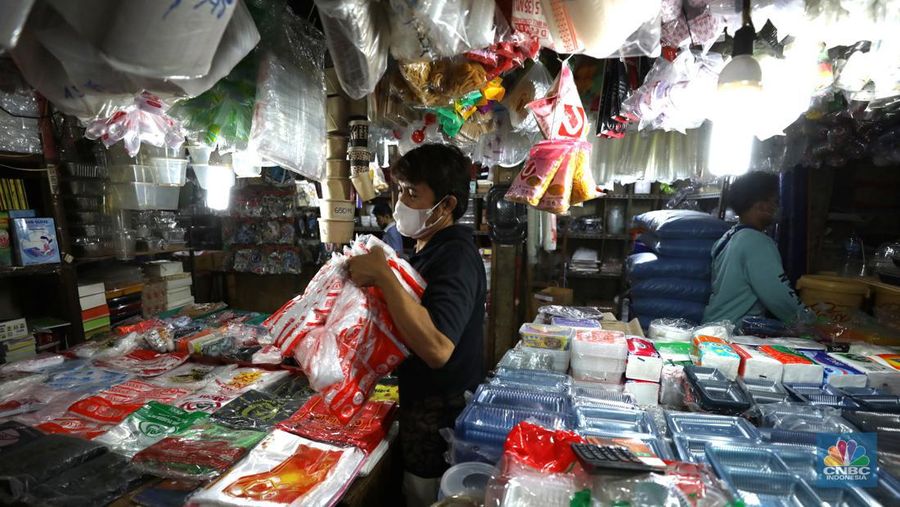 Pedagang melayani pembeli kantong plastik di Pasar Jaya Slipi, Jakarta, Rabu (9/3/2022). Lonjakan harga minyak mentah mendongkrak kenaikan harga bahan baku plastik. Baik untuk jenis Low Density Polyethylene (LDPE), Linear Low Density Polyethylene (LLDPE), High Density Polyethylene (HDPE), maupun Polypropylene (PP). (CNBC Indonesia/ Tri Susilo)
