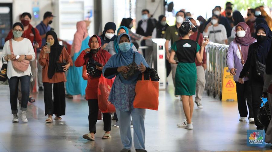 Penumpang berjalan menuju peron unuk menaiki KRL Commuter Line di Stasiun Tanah Abang, Jakarta, Rabu (9/3/2022). Petugas KAI Commuter telah mencabut dan membersihkan marka jaga jarak yang sebelumnya ada dari tempat duduk di KRL. (CNBC Indonesia/ Muhammad Sabki)