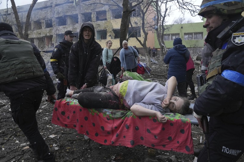 Kondisi Rumah Sakit Mariupol yang rusak Usai Serangan Rusia Ukrainian emergency employees and volunteers carry an injured pregnant woman from the damaged by shelling maternity hospital in Mariupol, Ukraine, Wednesday, March 9, 2022. A Russian attack has severely damaged a maternity hospital in the besieged port city of Mariupol, Ukrainian officials say. (AP Photo/Evgeniy Maloletka)