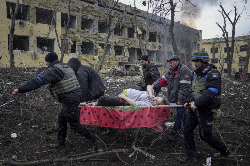 Kondisi Rumah Sakit Mariupol yang rusak Usai Serangan Rusia Ukrainian emergency employees and volunteers carry an injured pregnant woman from the damaged by shelling maternity hospital in Mariupol, Ukraine, Wednesday, March 9, 2022. A Russian attack has severely damaged a maternity hospital in the besieged port city of Mariupol, Ukrainian officials say. (AP Photo/Evgeniy Maloletka)
