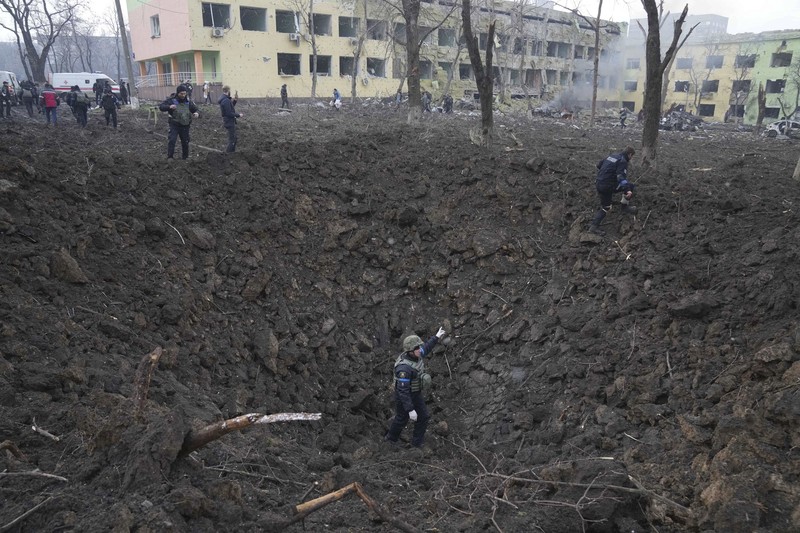 Ukrainian emergency employees and volunteers carry an injured pregnant woman from the damaged by shelling maternity hospital in Mariupol, Ukraine, Wednesday, March 9, 2022. A Russian attack has severely damaged a maternity hospital in the besieged port city of Mariupol, Ukrainian officials say. (AP Photo/Evgeniy Maloletka)