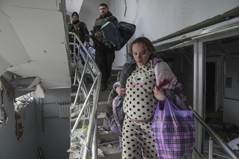 Kondisi Rumah Sakit Mariupol yang rusak Usai Serangan Rusia Ukrainian emergency employees and volunteers carry an injured pregnant woman from the damaged by shelling maternity hospital in Mariupol, Ukraine, Wednesday, March 9, 2022. A Russian attack has severely damaged a maternity hospital in the besieged port city of Mariupol, Ukrainian officials say. (AP Photo/Evgeniy Maloletka)