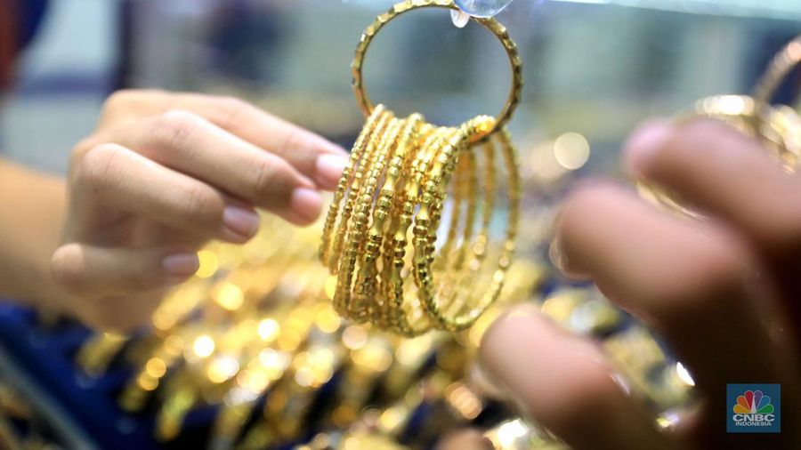 Pekerja menata perhiasan emas di toko emas Kawasan Pasar Ciputat, Tangerang Selatan, Jumat (11/3/2022). Harga emas dunia bergerak melemah pada perdagangan hari ini.  (CNBC Indonesia/ Muhammad Sabki)