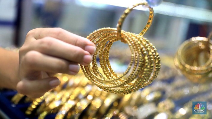 Pekerja menata perhiasan emas di toko emas Kawasan Pasar Ciputat, Tangerang Selatan, Jumat (11/3/2022). Harga emas dunia bergerak melemah pada perdagangan hari ini.  (CNBC Indonesia/ Muhammad Sabki)