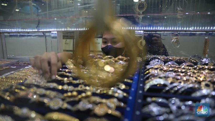 Pekerja menata perhiasan emas di toko emas Kawasan Pasar Ciputat, Tangerang Selatan, Jumat (11/3/2022). Harga emas dunia bergerak melemah pada perdagangan hari ini.  (CNBC Indonesia/ Muhammad Sabki)