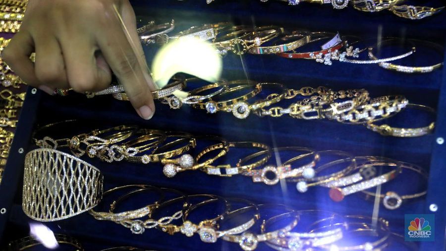 Pekerja menata perhiasan emas di toko emas Kawasan Pasar Ciputat, Tangerang Selatan, Jumat (11/3/2022). Harga emas dunia bergerak melemah pada perdagangan hari ini.  (CNBC Indonesia/ Muhammad Sabki)