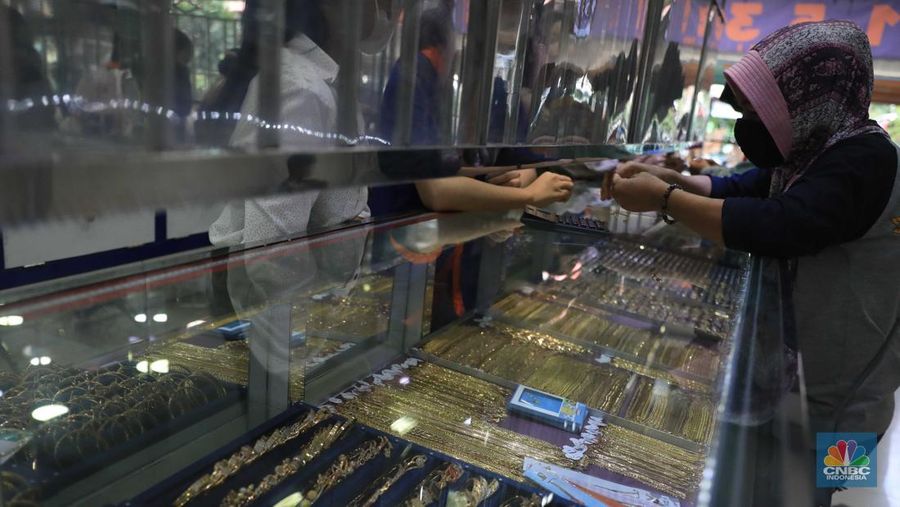 Pekerja menata perhiasan emas di toko emas Kawasan Pasar Ciputat, Tangerang Selatan, Jumat (11/3/2022). Harga emas dunia bergerak melemah pada perdagangan hari ini.  (CNBC Indonesia/ Muhammad Sabki)
