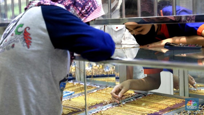 Pekerja menata perhiasan emas di toko emas Kawasan Pasar Ciputat, Tangerang Selatan, Jumat (11/3/2022). Harga emas dunia bergerak melemah pada perdagangan hari ini.  (CNBC Indonesia/ Muhammad Sabki)