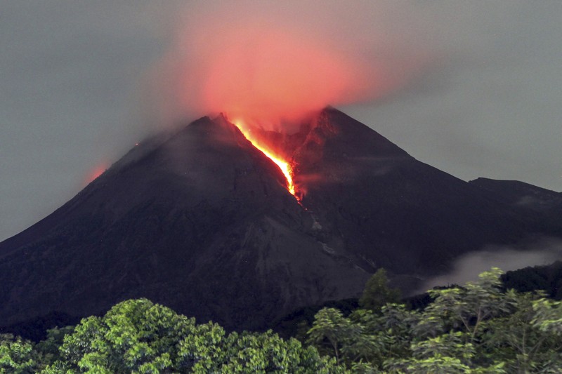 Lahar mengalir dari kawah Gunung Merapi terlihat dari desa Cangkringan di Sleman, Yogyakarta, Jumat dini hari (11/3/2022). Lahar mengalir dari kawah Gunung Merapi terlihat dari desa Cangkringan di Sleman, Yogyakarta, Jumat dini hari (11/3/2022). Letusan Gunung Merapi di Indonesia berlanjut pada Jumat, memaksa pihak berwenang untuk menghentikan kegiatan pariwisata dan penambangan di lerengnya karena bahaya di gunung berapi paling aktif di negara ini. (AP Photo/Slamet Riyadi)