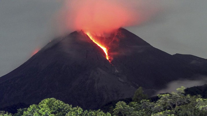 Lahar mengalir dari kawah Gunung Merapi terlihat dari desa Cangkringan di Sleman, Yogyakarta, Jumat dini hari (11/3/2022). Letusan Gunung Merapi di Indonesia berlanjut pada Jumat, memaksa pihak berwenang untuk menghentikan kegiatan pariwisata dan penambangan di lerengnya karena bahaya di gunung berapi paling aktif di negara ini. (AP Photo/Slamet Riyadi)