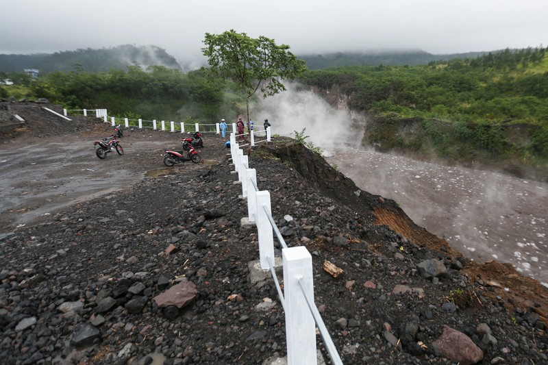 Lahar mengalir dari kawah Gunung Merapi terlihat dari desa Cangkringan di Sleman, Yogyakarta, Jumat dini hari (11/3/2022). Letusan Gunung Merapi di Indonesia berlanjut pada Jumat, memaksa pihak berwenang untuk menghentikan kegiatan pariwisata dan penambangan di lerengnya karena bahaya di gunung berapi paling aktif di negara ini. (AP Photo/Slamet Riyadi)