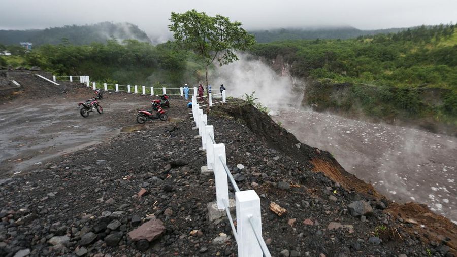 Lahar mengalir dari kawah Gunung Merapi terlihat dari desa Cangkringan di Sleman, Yogyakarta, Jumat dini hari (11/3/2022). Letusan Gunung Merapi di Indonesia berlanjut pada Jumat, memaksa pihak berwenang untuk menghentikan kegiatan pariwisata dan penambangan di lerengnya karena bahaya di gunung berapi paling aktif di negara ini. (AP Photo/Slamet Riyadi)
