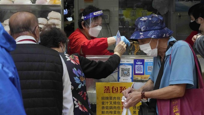 Virus Outbreak Hong Kong People wearing face masks line up to buy lunch boxes for take-away orders at a shop in Hong Kong, Sunday, March 13, 2022. The territory's leader, Chief Executive Carrie Lam, warned the peak of the latest surge in coronavirus infections might not have passed yet. (AP Photo/Kin Cheung)