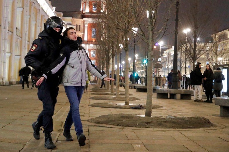 Aparat penegak hukum Rusia menahan seorang demonstran selama protes anti-perang terhadap invasi Rusia ke Ukraina, di Saint Petersburg, Rusia. (REUTERS/STRINGER)