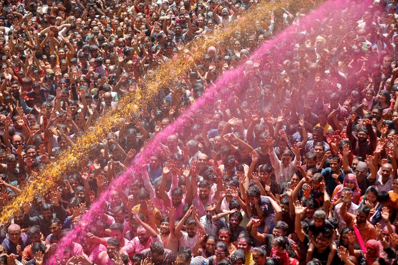 Hindu priests spray coloured water on the devotees at a temple's premises during Holi celebrations in Ahmedabad, India, March 18, 2022. REUTERS/Amit Dave REFILE- CORRECTING INFORMATION