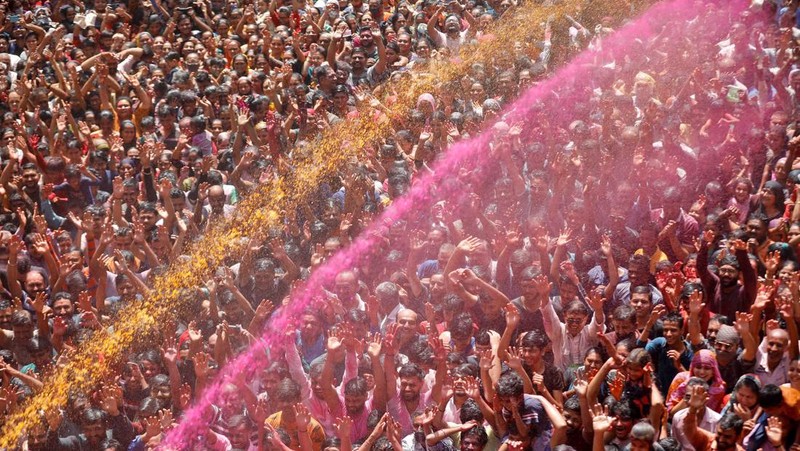 Hindu priests spray coloured water on the devotees at a temple's premises during Holi celebrations in Ahmedabad, India, March 18, 2022. REUTERS/Amit Dave REFILE- CORRECTING INFORMATION