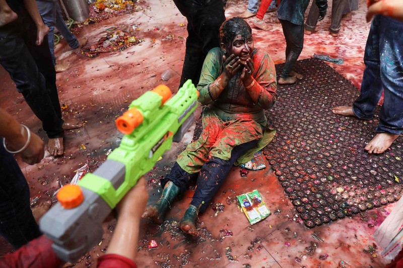FESTIVAL-HOLI/INDIA Hindu priests spray coloured water on the devotees at a temple's premises during Holi celebrations in Ahmedabad, India, March 18, 2022. REUTERS/Amit Dave REFILE- CORRECTING INFORMATION