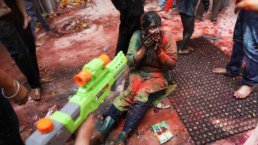 Hindu priests spray coloured water on the devotees at a temple's premises during Holi celebrations in Ahmedabad, India, March 18, 2022. REUTERS/Amit Dave REFILE- CORRECTING INFORMATION