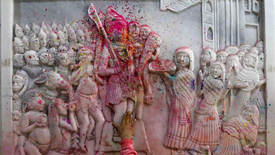 Hindu priests spray coloured water on the devotees at a temple's premises during Holi celebrations in Ahmedabad, India, March 18, 2022. REUTERS/Amit Dave REFILE- CORRECTING INFORMATION