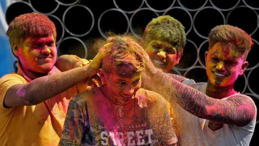 Hindu priests spray coloured water on the devotees at a temple's premises during Holi celebrations in Ahmedabad, India, March 18, 2022. REUTERS/Amit Dave REFILE- CORRECTING INFORMATION