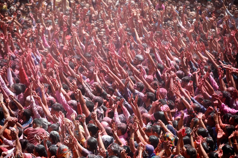 Hindu priests spray coloured water on the devotees at a temple's premises during Holi celebrations in Ahmedabad, India, March 18, 2022. REUTERS/Amit Dave REFILE- CORRECTING INFORMATION