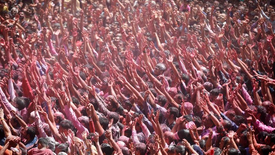 Hindu priests spray coloured water on the devotees at a temple's premises during Holi celebrations in Ahmedabad, India, March 18, 2022. REUTERS/Amit Dave REFILE- CORRECTING INFORMATION
