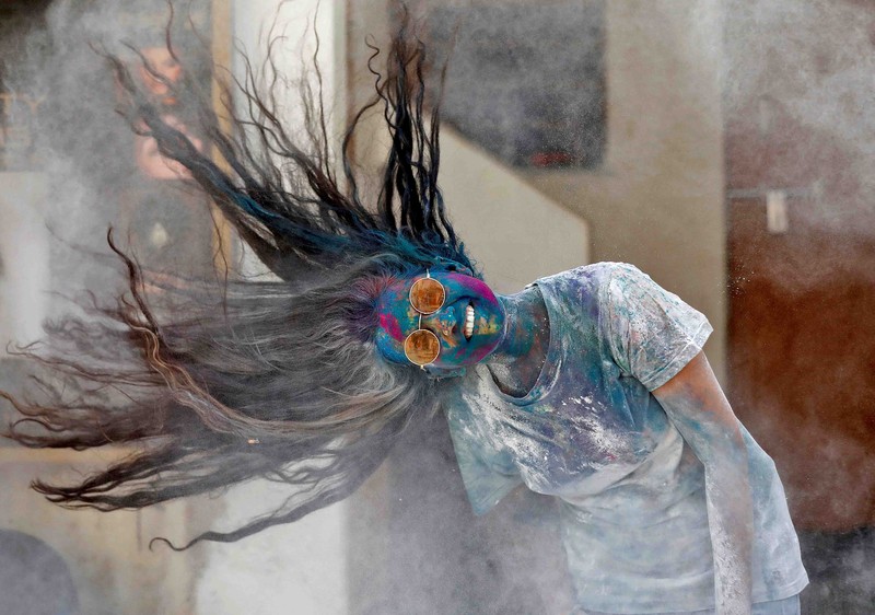 Hindu priests spray coloured water on the devotees at a temple's premises during Holi celebrations in Ahmedabad, India, March 18, 2022. REUTERS/Amit Dave REFILE- CORRECTING INFORMATION