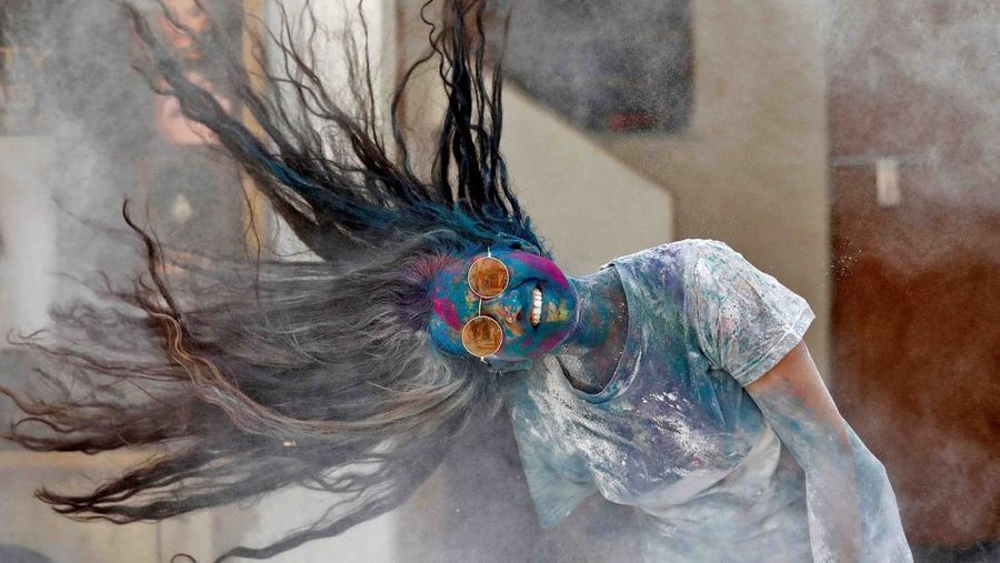 Hindu priests spray coloured water on the devotees at a temple's premises during Holi celebrations in Ahmedabad, India, March 18, 2022. REUTERS/Amit Dave REFILE- CORRECTING INFORMATION