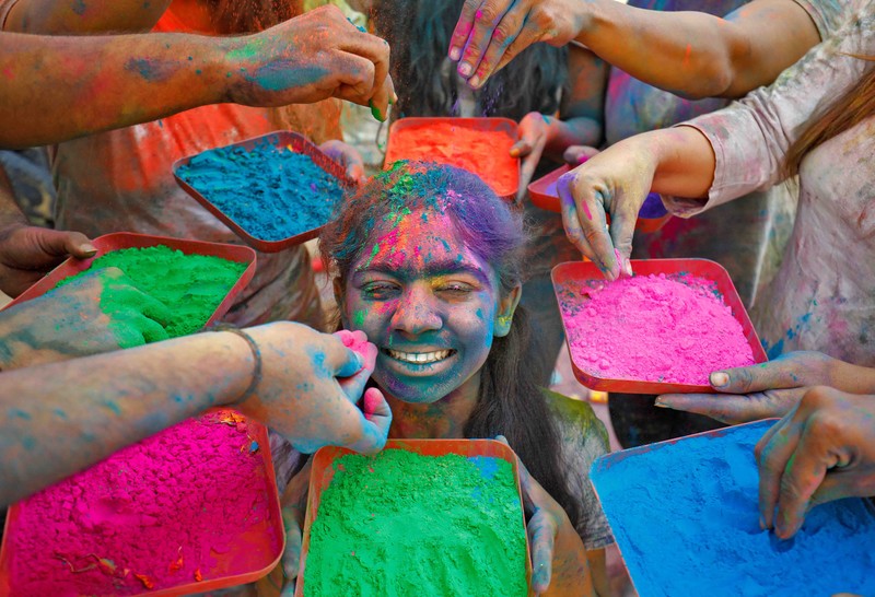 Hindu priests spray coloured water on the devotees at a temple's premises during Holi celebrations in Ahmedabad, India, March 18, 2022. REUTERS/Amit Dave REFILE- CORRECTING INFORMATION
