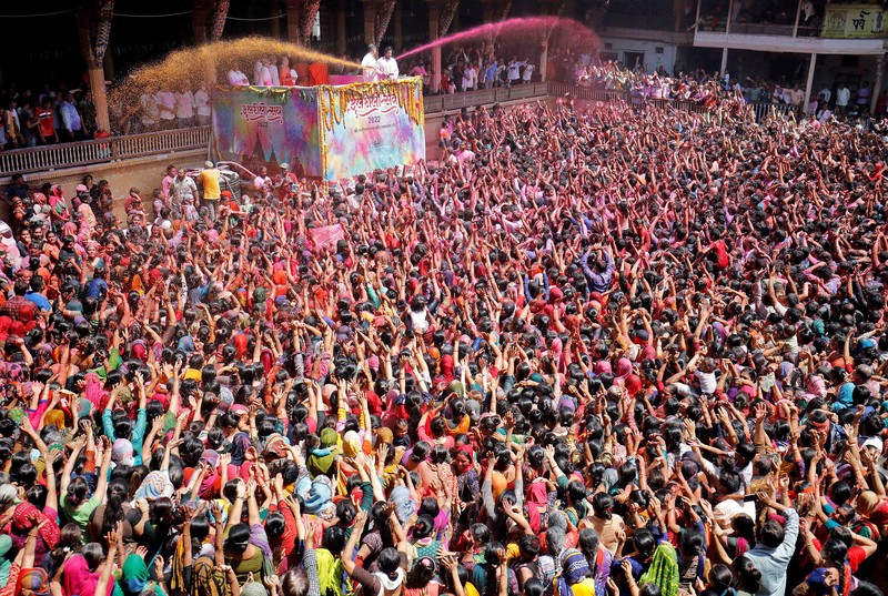Hindu priests spray coloured water on the devotees at a temple's premises during Holi celebrations in Ahmedabad, India, March 18, 2022. REUTERS/Amit Dave REFILE- CORRECTING INFORMATION