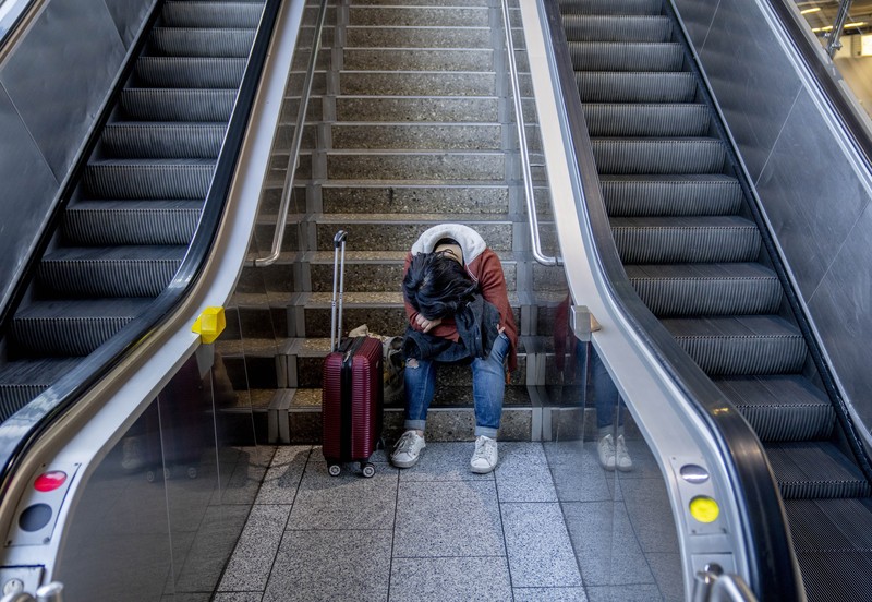 Germany Airport Strike Travelers stand in front of a display board in an airport terminal in Hamburg, Germany, in the morning of Tuesday, March 22, 2022. Due to a warning strike by the trade union ver.di, the security checkpoint remains closed all day and no departures take place. (Daniel Bockwoldt/dpa via AP)