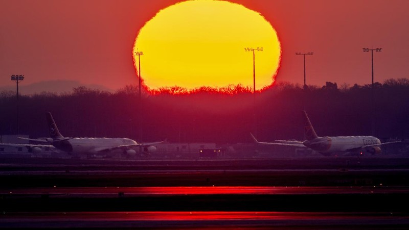 Travelers stand in front of a display board in an airport terminal in Hamburg, Germany, in the morning of Tuesday, March 22, 2022. Due to a warning strike by the trade union ver.di, the security checkpoint remains closed all day and no departures take place. (Daniel Bockwoldt/dpa via AP)
