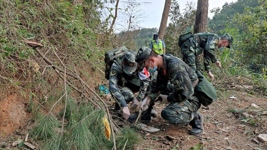 A police officer carries a traffic cone after police vehicles enter Lu village near the site where a China Eastern Airlines Boeing 737-800 plane flying from Kunming to Guangzhou crashed, in Wuzhou, Guangxi Zhuang Autonomous Region, China March 22, 2022. REUTERS/Carlos Garcia Rawlins