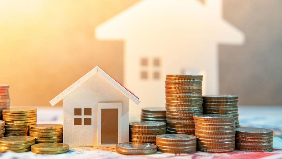 Real estate or property investment. Home mortgage loan rate. Saving money for retirement concept. Coin stack on international banknotes with house model on table. Business growth background