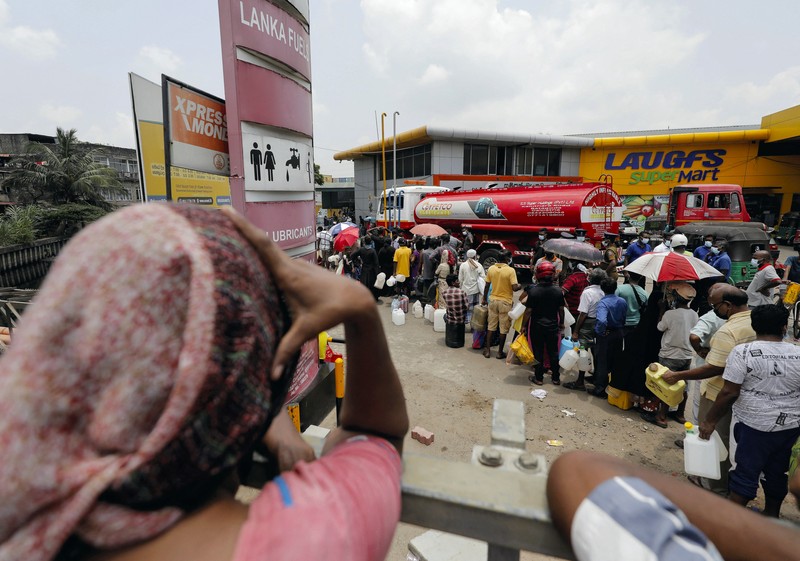 SRI LANKA-CRISIS/ People stand in a long queue to buy kerosene oil for kerosene cookers amid a shortage of domestic gas due to country's economic crisis, at a fuel station in Colombo, Sri Lanka March 21, 2022. REUTERS/Dinuka Liyanawatte