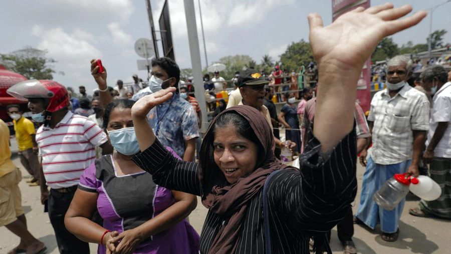 A woman celebrates as the first oil bowser with kerosene arrives as people wait to buy kerosene oil for kerosene cookers amid a shortage of domestic gas due to country's economic crisis, at a fuel station in Colombo, Sri Lanka March 21, 2022. REUTERS/Dinuka Liyanawatte