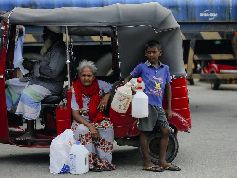 People stand in a long queue to buy kerosene oil for kerosene cookers amid a shortage of domestic gas due to country's economic crisis, at a fuel station in Colombo, Sri Lanka March 21, 2022. REUTERS/Dinuka Liyanawatte