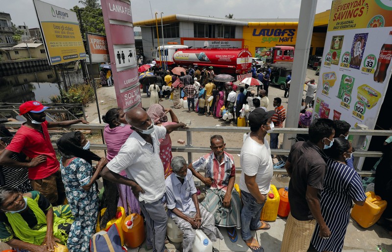 SRI LANKA-CRISIS/ People stand in a long queue to buy kerosene oil for kerosene cookers amid a shortage of domestic gas due to country's economic crisis, at a fuel station in Colombo, Sri Lanka March 21, 2022. REUTERS/Dinuka Liyanawatte
