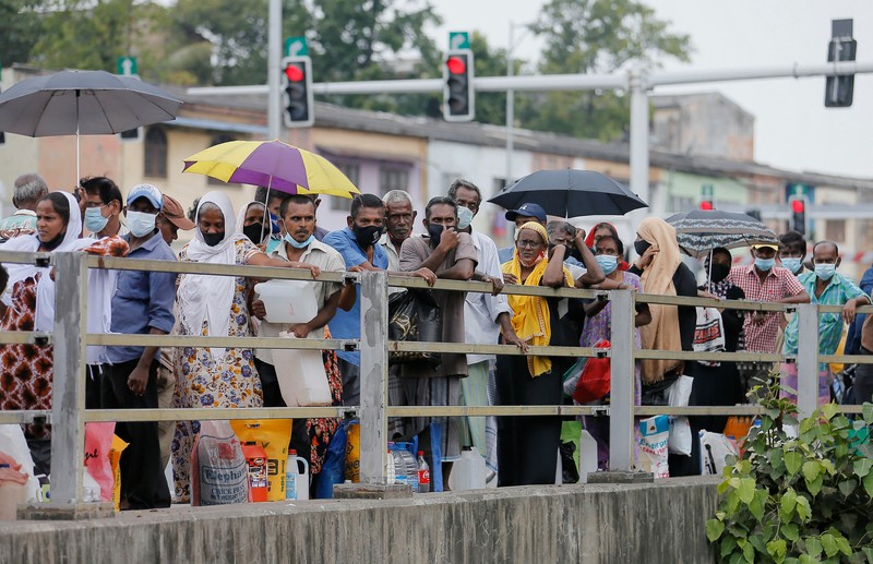 People stand in a long queue to buy kerosene oil for kerosene cookers amid a shortage of domestic gas due to country's economic crisis, at a fuel station in Colombo, Sri Lanka March 21, 2022. REUTERS/Dinuka Liyanawatte