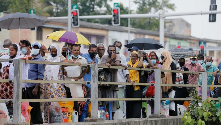 People stand in a long queue to buy kerosene oil for their kerosene cookers amid a shortage of domestic gas due to country's economic crisis, at a fuel station in Colombo, Sri Lanka March 21, 2022. REUTERS/Dinuka Liyanawatte