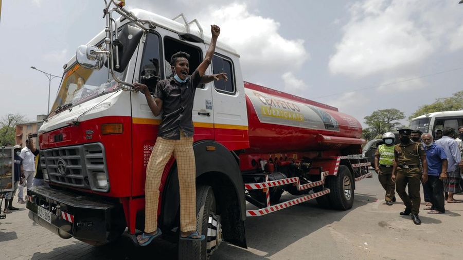 A man celebrates as the first oil bowser with kerosene arrives, as people wait to buy kerosene oil for their kerosene cookers amid a shortage of domestic gas due to country's economic crisis, at a fuel station in Colombo, Sri Lanka March 21, 2022. REUTERS/Dinuka Liyanawatte