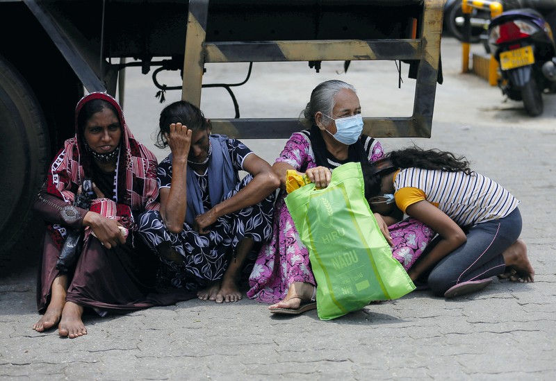SRI LANKA-CRISIS/ People stand in a long queue to buy kerosene oil for kerosene cookers amid a shortage of domestic gas due to country's economic crisis, at a fuel station in Colombo, Sri Lanka March 21, 2022. REUTERS/Dinuka Liyanawatte